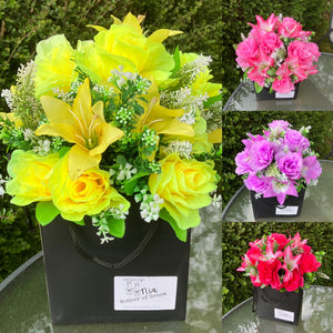 flower arrangement of artificial roses and lilies in black box