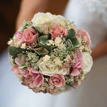 A wedding bouquet of ivory and dusky pink artificial flowers