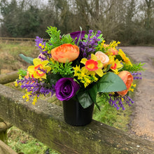 a grave pot with flowers featuring  artificial silk blooms