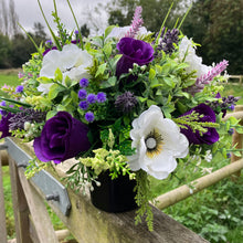 a memorial silk flower arrangement in shades of cream and purple