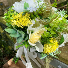 A brides bouquet of roses, peonies and fern