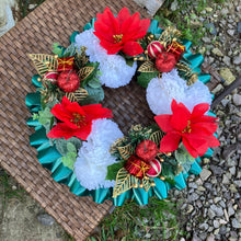 a memorial christmas wreath featuring baubles, cones and poinsettia