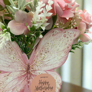 An artificial flower arrangement in butterfly container