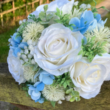 A brides bouquet of white/ivory and pale blue artificial silk flowers