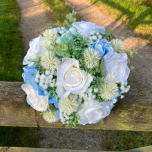 A brides bouquet of white/ivory and pale blue artificial silk flowers