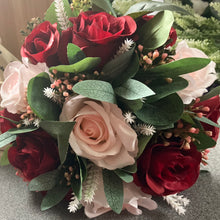 A wedding bouquet of artificial pink and burgundy roses