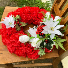 A lge memorial wreath with carnations roses and poinsettia flowers