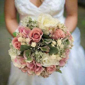 A wedding bouquet of ivory and dusky pink artificial flowers