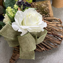 A heart wreath with faux roses and foliage