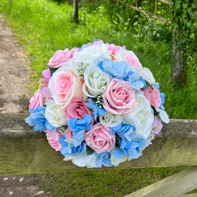 brides wedding bouquet of artificial ivory,blue and pink rose flowers with diamantes