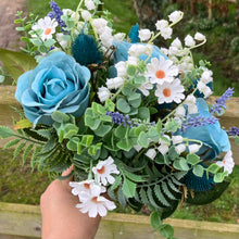 A wedding bouquet of white and teal flowers and foliage