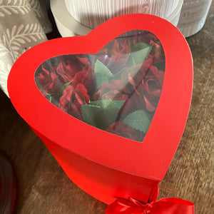 A Flower arrangement of red roses and ferrero rocha in red heart box