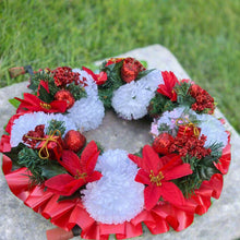 a memorial christmas wreath featuring baubles, cones and poinsettia