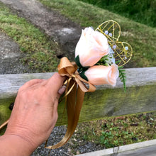 A wedding bouquet featuring silk flowers in shades of ivory and peach