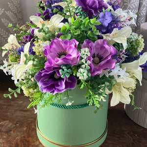 A handtied arrangement of purple and ivory flowers & foliage