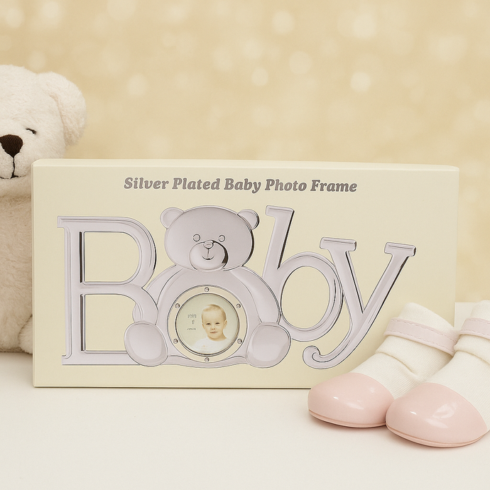 Silver-plated baby photo frame with teddy bear design on a beige background