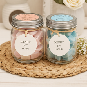 Two jars of scented wax melt with decorative tags on a woven mat.