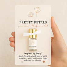 Pretty Petals premium perfume oil packaging held by a hand on a beige background