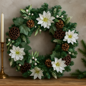 Decorative wreath with white flowers, pinecones, and greenery on a neutral background