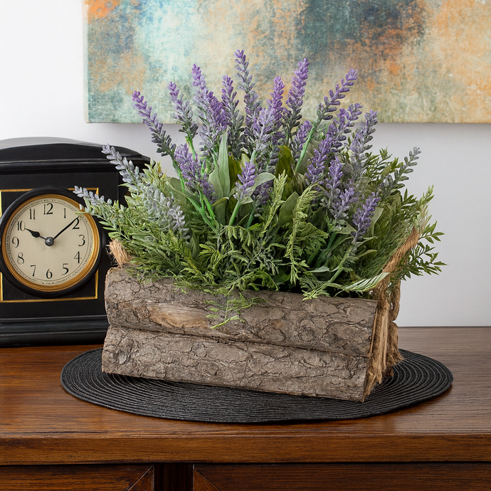 Decorative arrangement of lavender and greenery in a wooden log container on a table with a clock in the background.
