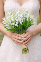 A wedding bouquet of pure white artificial lily of the valley flowers
