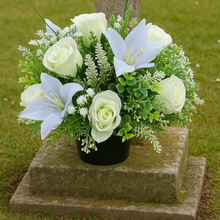 Ivory memorial flowers arranged in black plastic pot