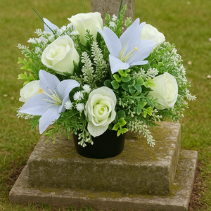 Ivory memorial flowers arranged in black plastic pot