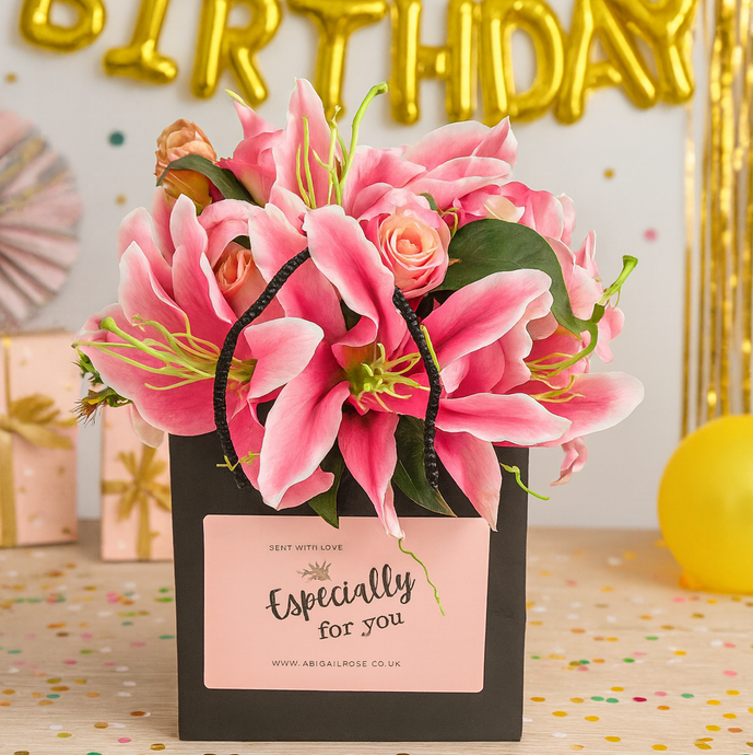 flower arrangement of artificial pink roses and lilies in black box