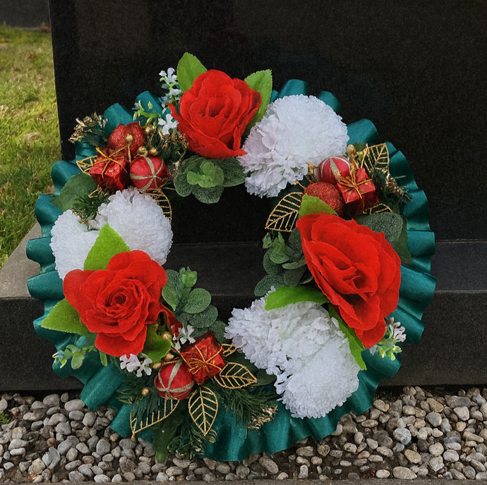 A christmas graveside memorial wreath of red roses and carnations
