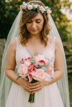 A wedding bouquet of coral and grey artificial roses and orchids