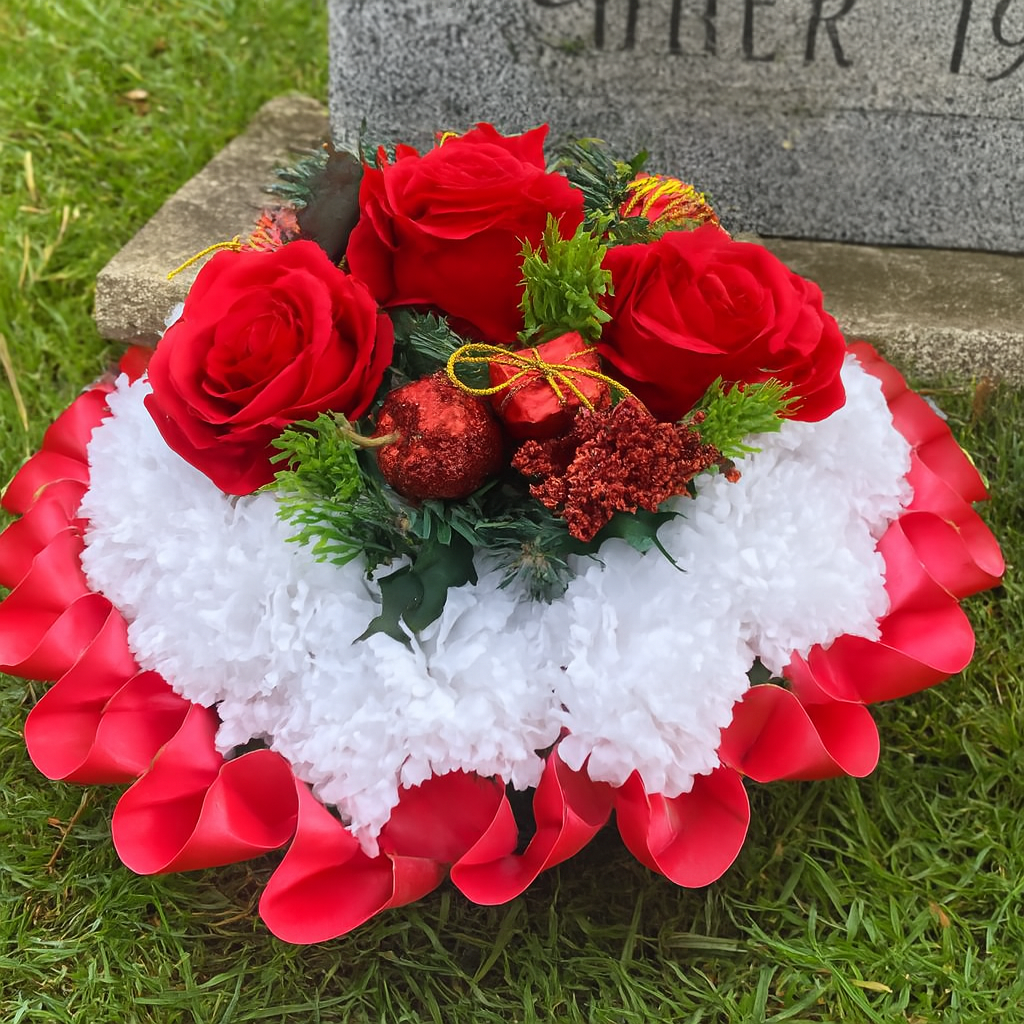 memorial wreath of artificial silk roses in shades of red