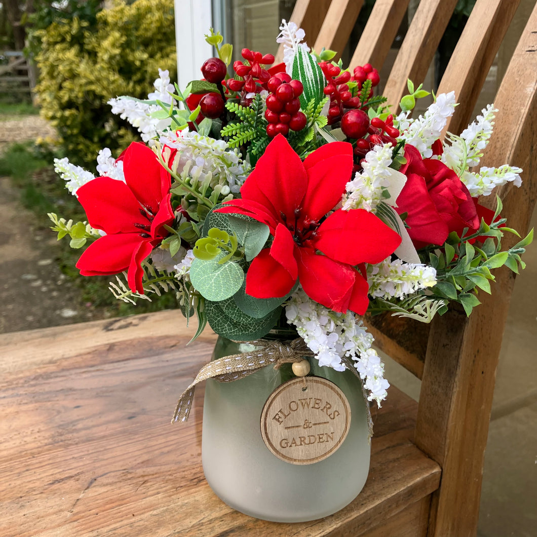 A christmas bouquet arranged in frosted glass vase