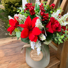 A christmas bouquet arranged in frosted glass vase