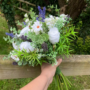 A brides bouquet of white calla, roses, lavender and foliage