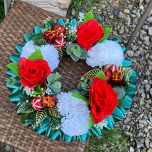 A christmas graveside memorial wreath of red roses and carnations