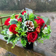 a christmas grave side memorial arrangement with red artificial roses