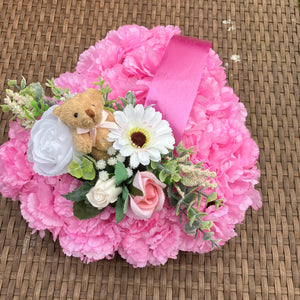 a personalised memorial heart of artificial silk roses and carnations in shades of pink