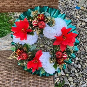 a memorial christmas wreath featuring baubles, cones and poinsettia