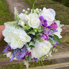 A brides bouquet featuring lilac, lavender and ivory artificial flowers