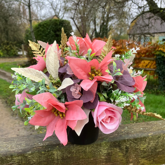 A Christmas graveside flower arrangement in black pot