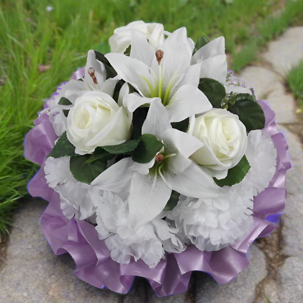 a funeral posy of artificial silk roses and lily flowers in shades of lilac and white