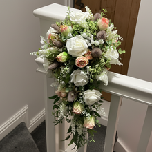 A wedding bouquet of artificial white and pink rose flowers