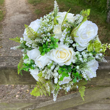 A wedding bouquet collection of white artificial silk roses peonies and gyp