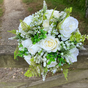 A wedding bouquet collection of white artificial silk roses peonies and gyp