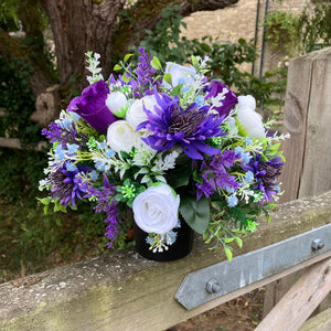 a grave pot with white artificial silk cornflowers and rose blooms