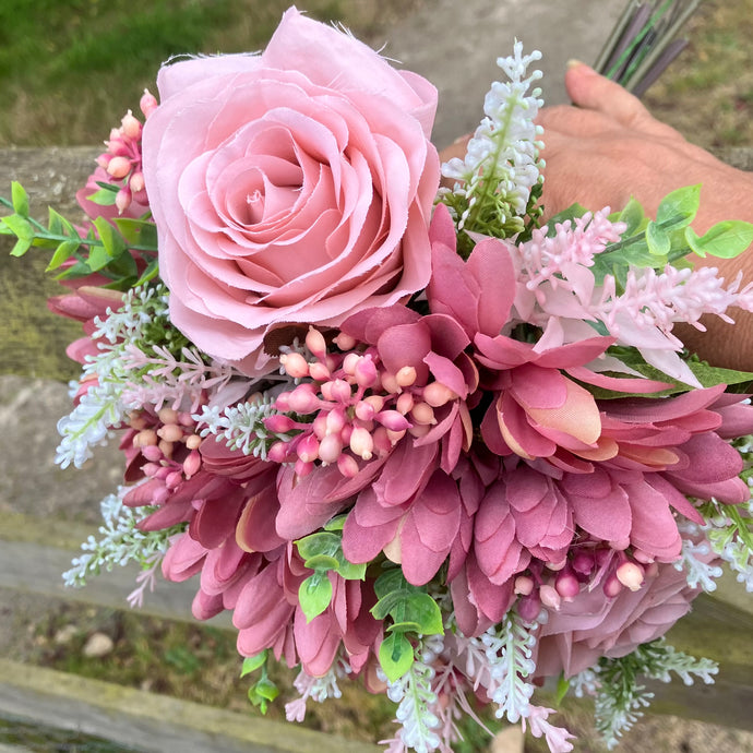 A brides posy featuring artificial pink silk gerbera and roses