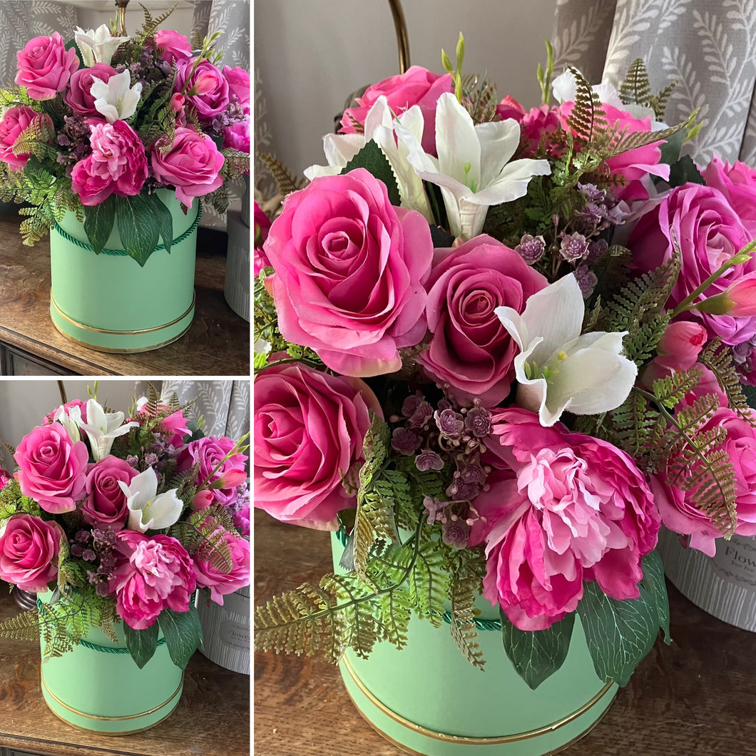A large handtied flower arrangement of deep pink and ivory silk flowers