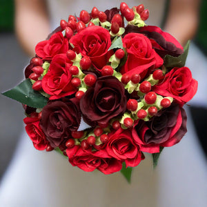 a wedding bouquet of red and burgundy silk roses & hypericum