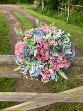 A wedding bouquet of artificial mauve and blue flowers