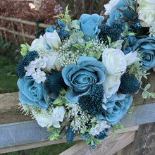 A wedding bouquet collection of ivory and teal flowers and foliage